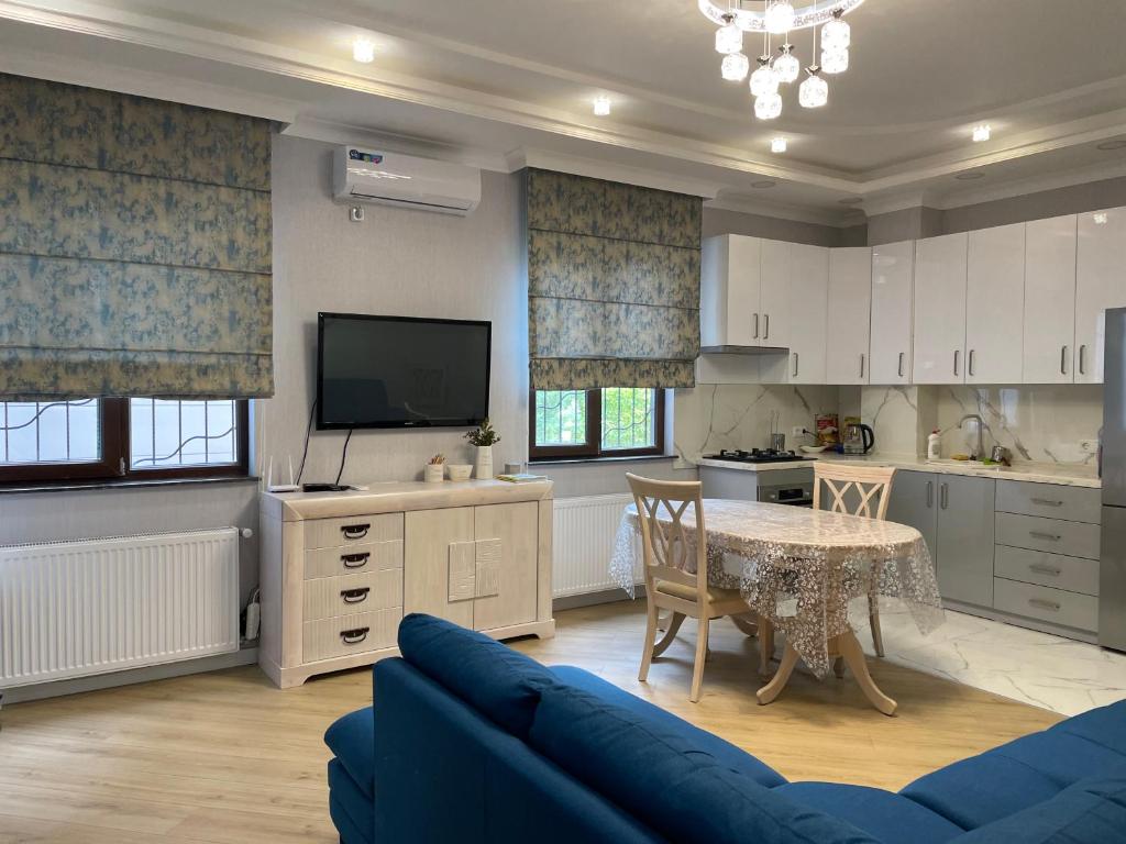 库塔伊西City Centre Apartment的厨房配有蓝色的沙发、桌子和电视。