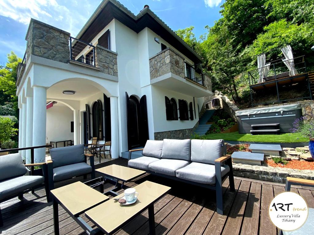 蒂豪尼ARTtrend Luxury Villa的房屋前设有带沙发和桌子的庭院。