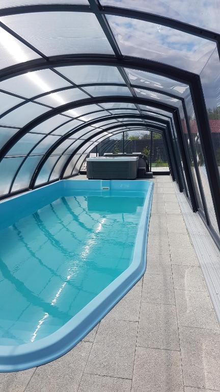 詹塔尔Osada Wypoczynku Jantar Resort&Spa - Luksusowe Domki z Basenem, Sauną i Jacuzzi的一座带天蓬的大型游泳池