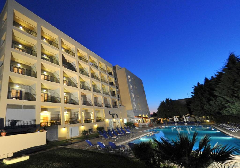 科孚镇Corfu Hellinis Hotel的大楼前设有游泳池的酒店