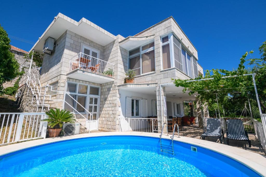 奥拉萨奇Apartment MARIO - veliki stan za odmor - terasa- vrt - bazen - pogled more, izoliran的一座房子前面设有游泳池