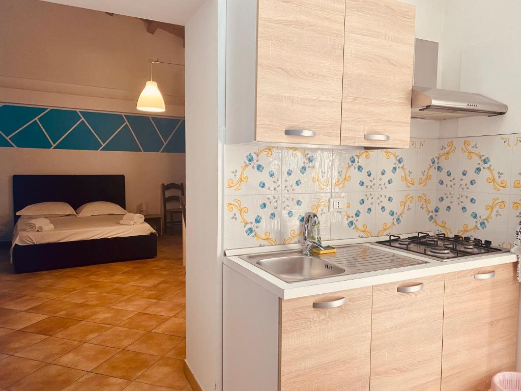 巴勒莫Cartari Apartment的带水槽的厨房和1间带1张床的卧室