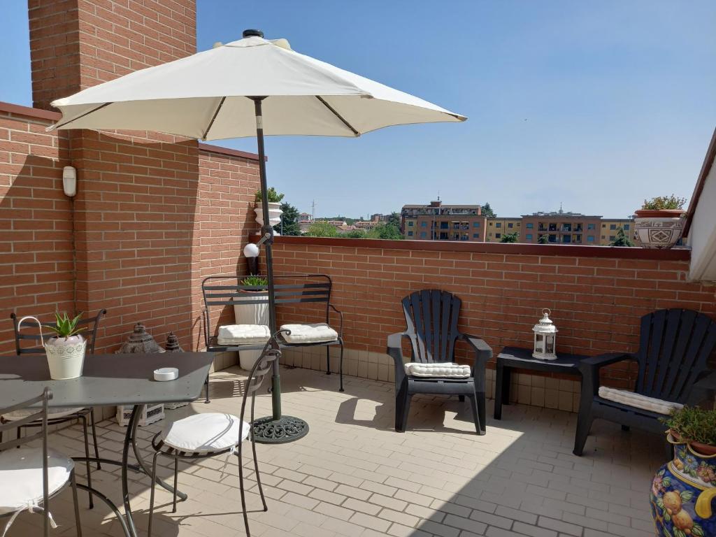 博拉泰La mansarda di Mi&Lo junior suite的一个带桌椅和遮阳伞的庭院
