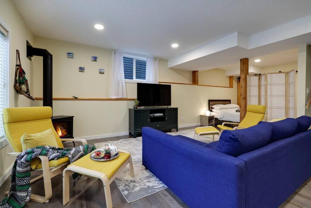 科克伦Adorable private suite with indoor fire place的客厅配有蓝色的沙发和黄色的椅子