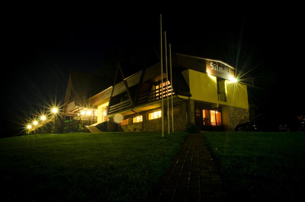 LaunkalneSilmači的一座晚上点亮的建筑,灯火通明