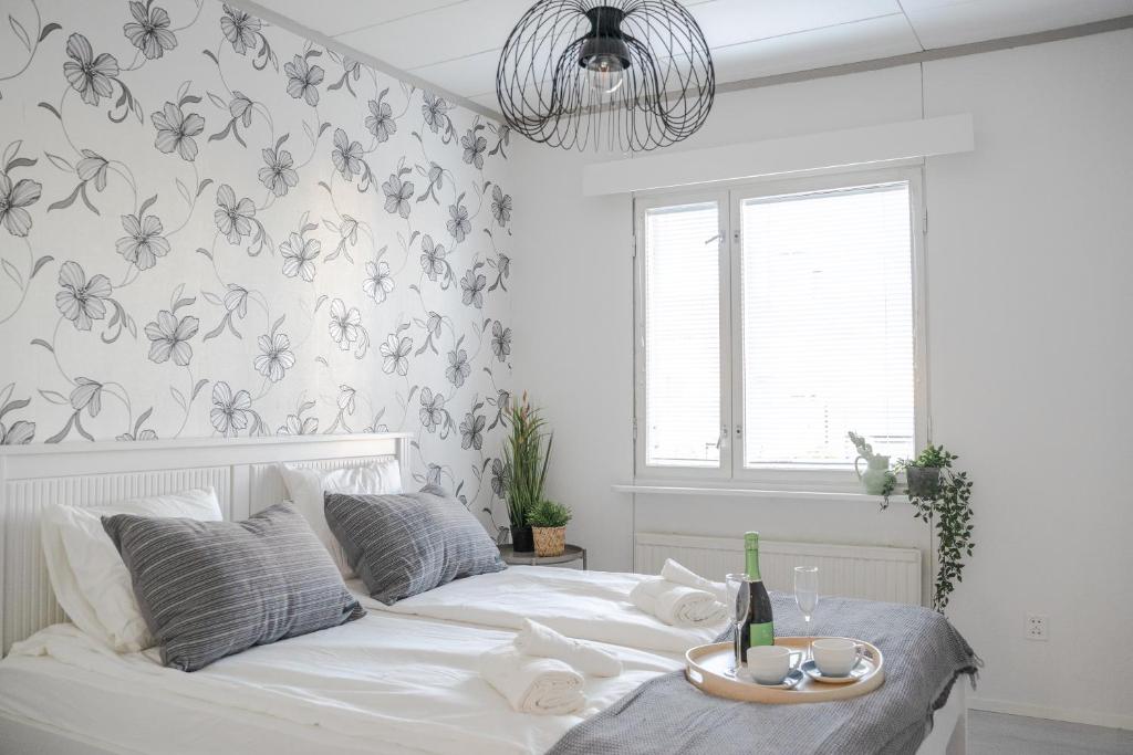 皮耶塔尔萨里West Coast Hideaway的卧室配有白色的床和华丽的壁纸