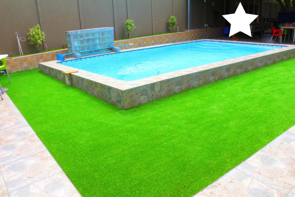开普敦MO MAJOR的庭院中绿草环绕的游泳池