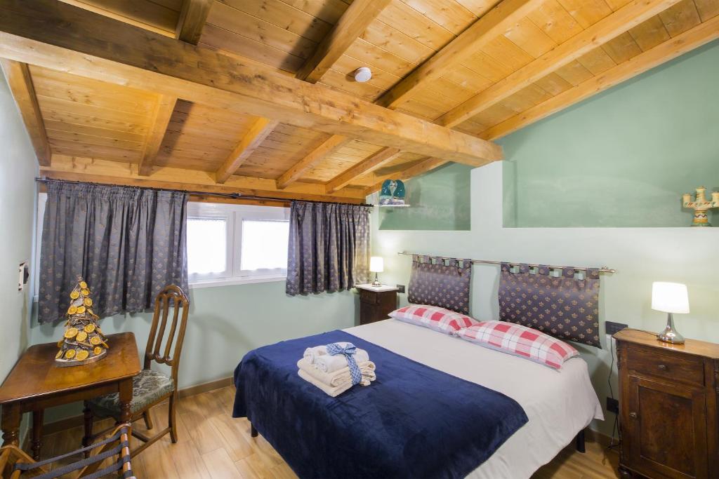 菲维扎诺Alla Porta Di Sotto B&B的一间卧室设有一张床和木制天花板