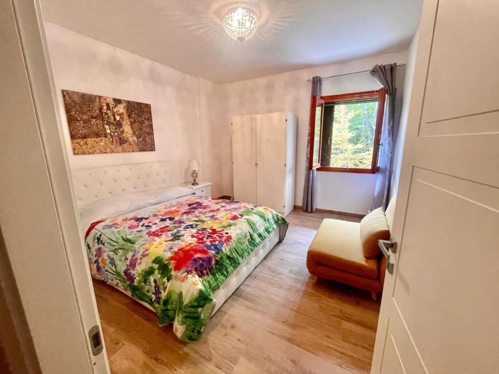 Prati di TivoLa Tana del Capriolo的一间卧室配有一张床和一把椅子
