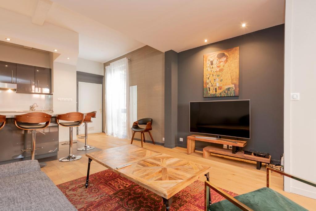 图卢兹Appartement de prestige – rue des Arts的客厅配有平面电视和桌子。