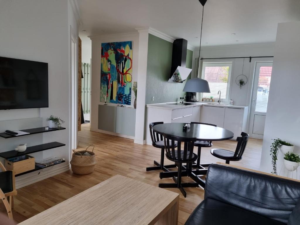 洛肯Løkken centrum ferielejlighed-apartment 4E的一间带桌子的客厅和一间厨房