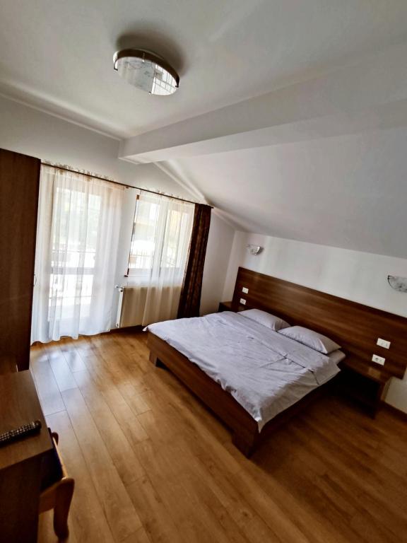 Statjunea BorsaPensiunea ANCA的一间卧室配有一张床,铺有木地板
