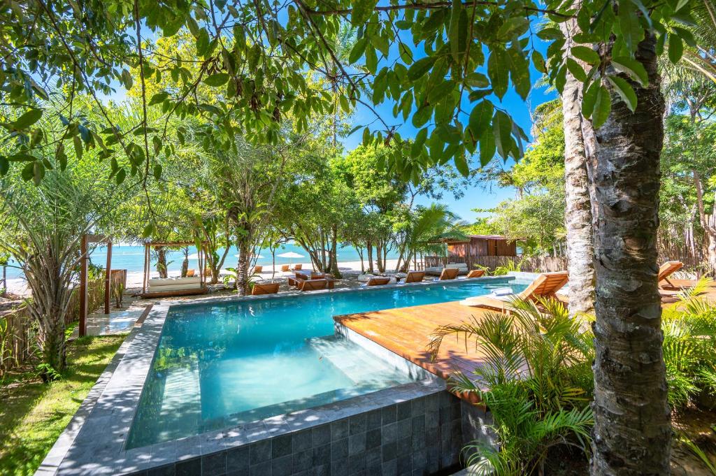伊尔哈德博伊巴Colibri Beach Villas的一座树木繁茂的度假村内的无边泳池
