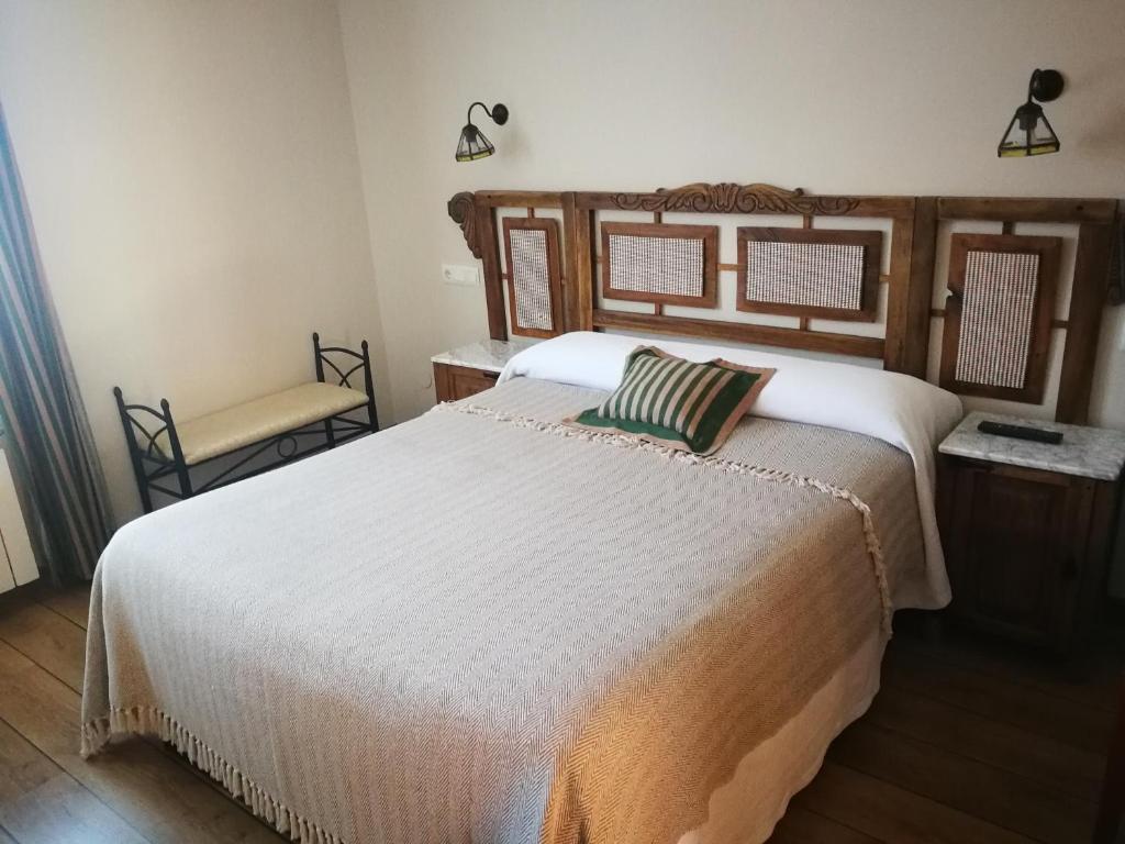 Villager de LacianaHotel rural La Campanona的卧室配有一张白色大床和一把椅子