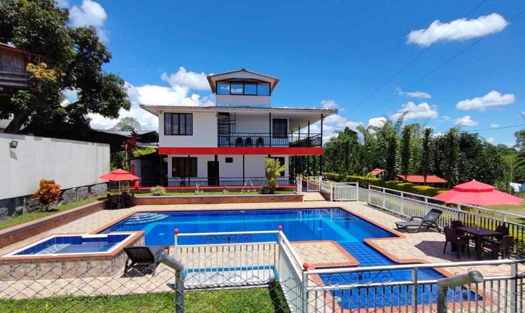 金巴亚Finca Hotel el Guadual的房屋前有游泳池的房子