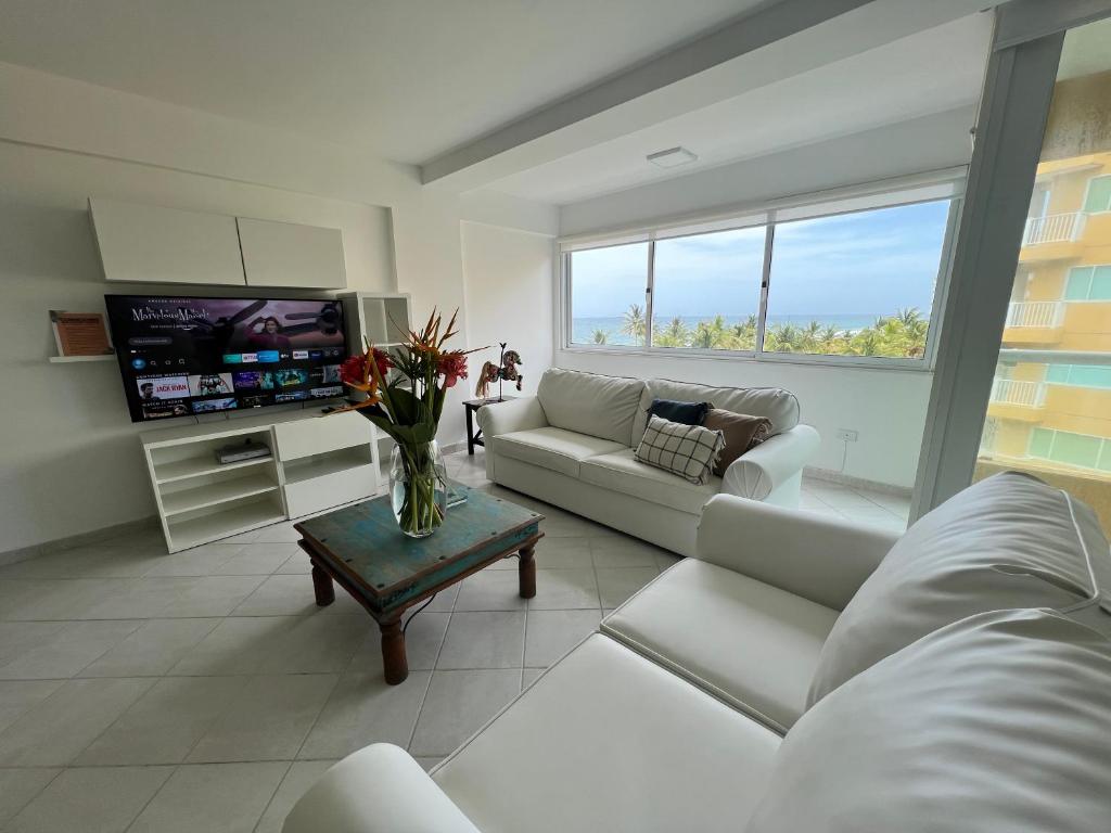 AricaguaCimarron Suites Playa Parguito的客厅配有白色家具和电视
