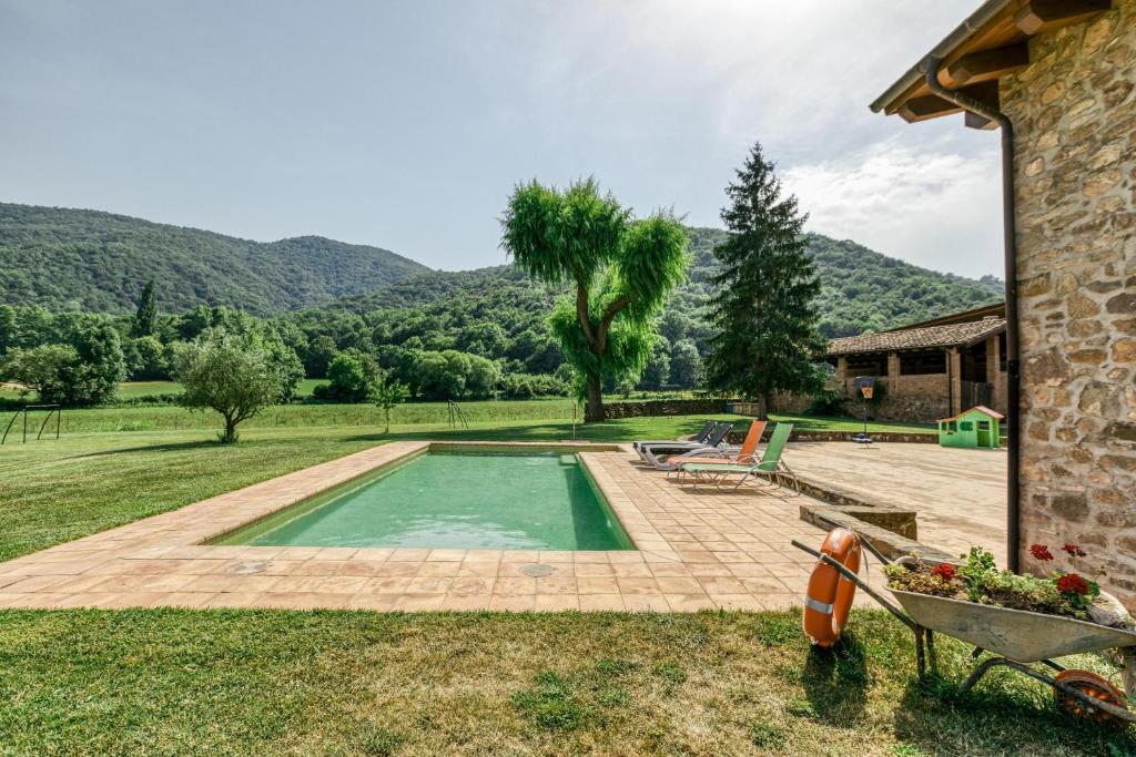 Vall de BianyaCasa rural Mas Plantalech的一座位于山丘庭院内的游泳池