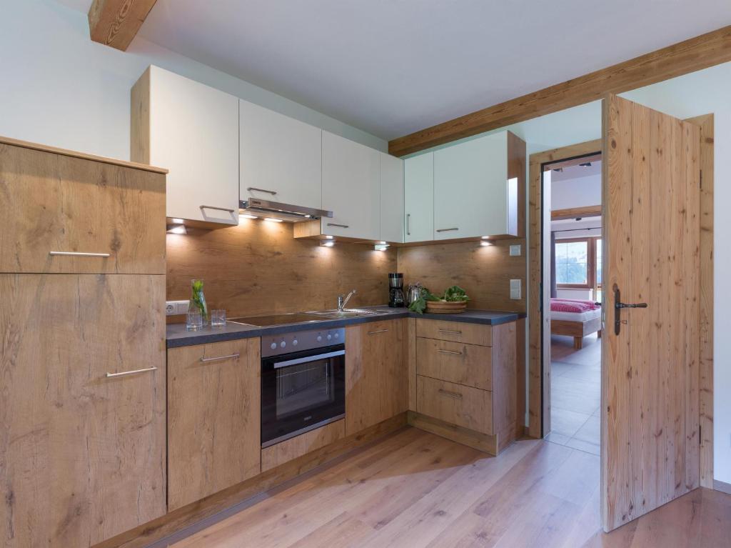 布里克森谷地霍普夫加尔滕BERGappartement KINK的厨房配有木制橱柜和炉灶。
