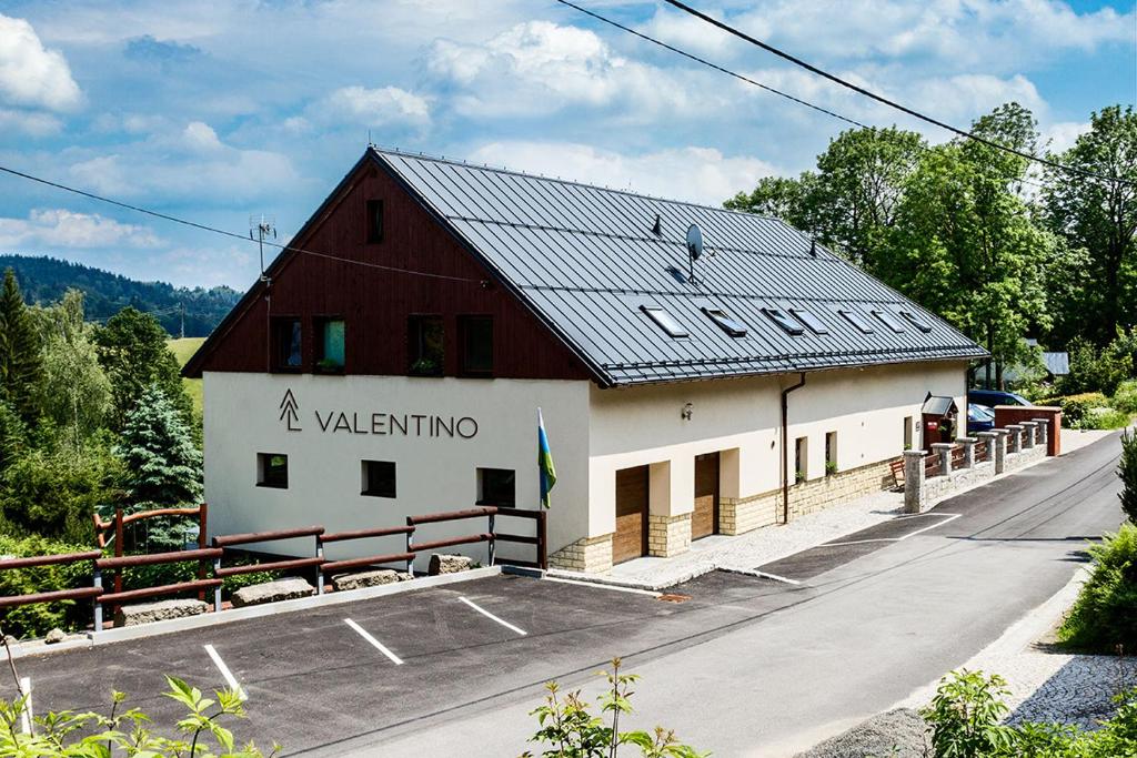 贝德日霍夫penzion Valentino的黑色屋顶的红色和白色建筑