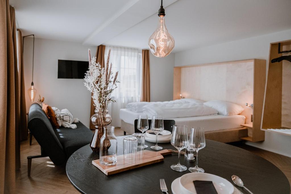 阿尔邦Hotel Müllers Self-Check-In的配有酒杯桌子和床的房间
