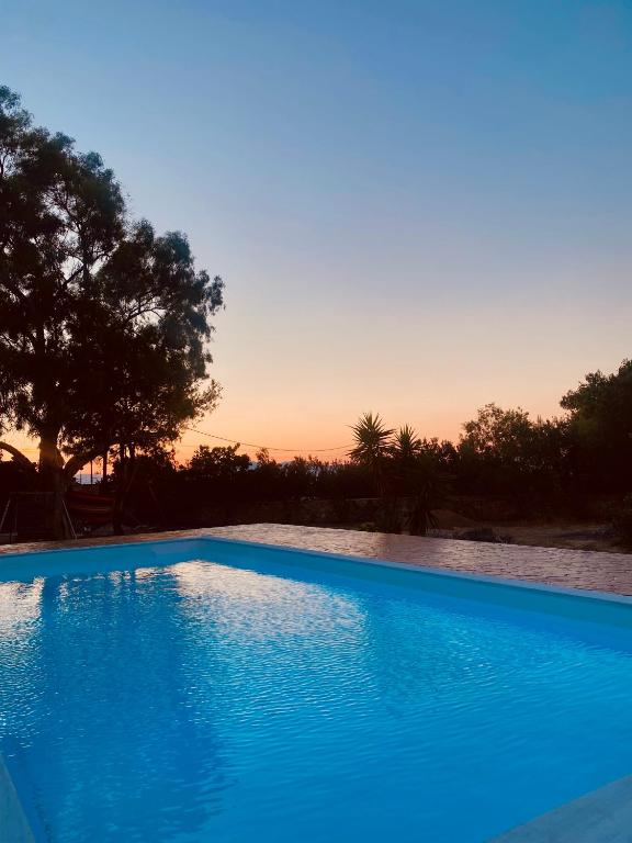 KhlóïSeaside "Stone & Light Villa II" close to Aegina City的蓝色的游泳池,背景是日落