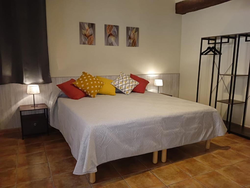 贝塞特Apartamento Burgués的卧室配有一张带彩色枕头的大型白色床。