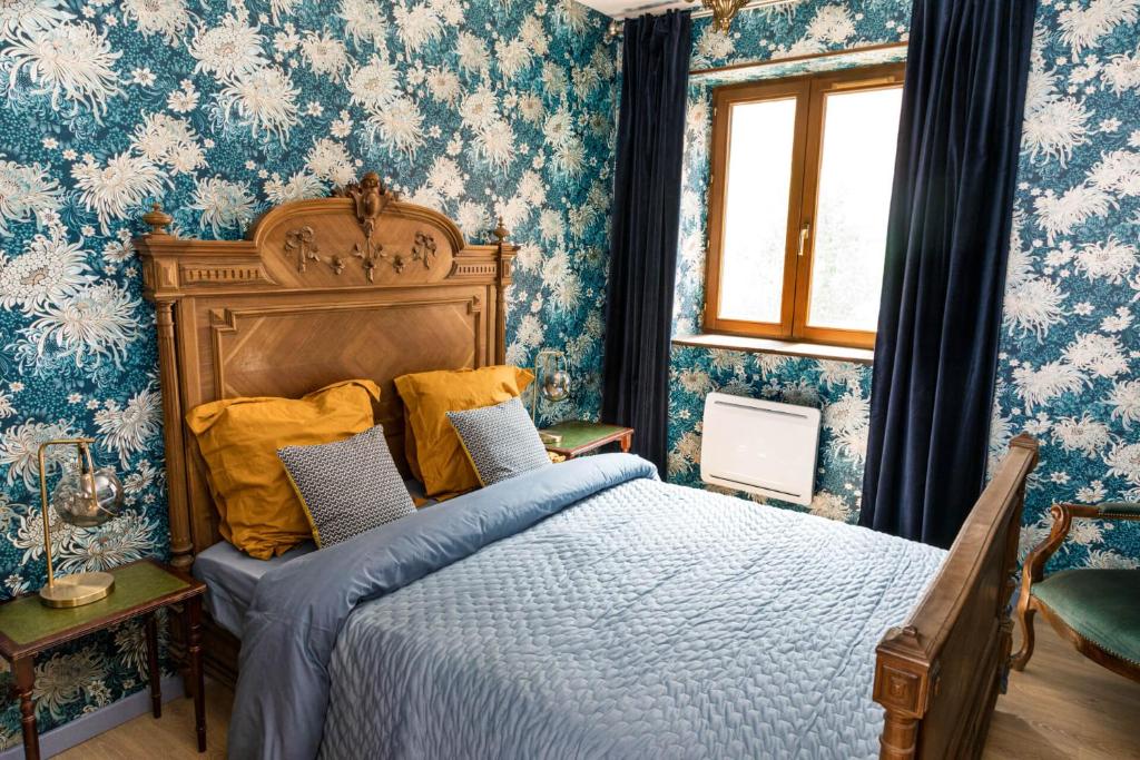 Étival-Clairefontainev i o l e t t e La souris des champs的一间卧室配有蓝色和白色壁纸的床