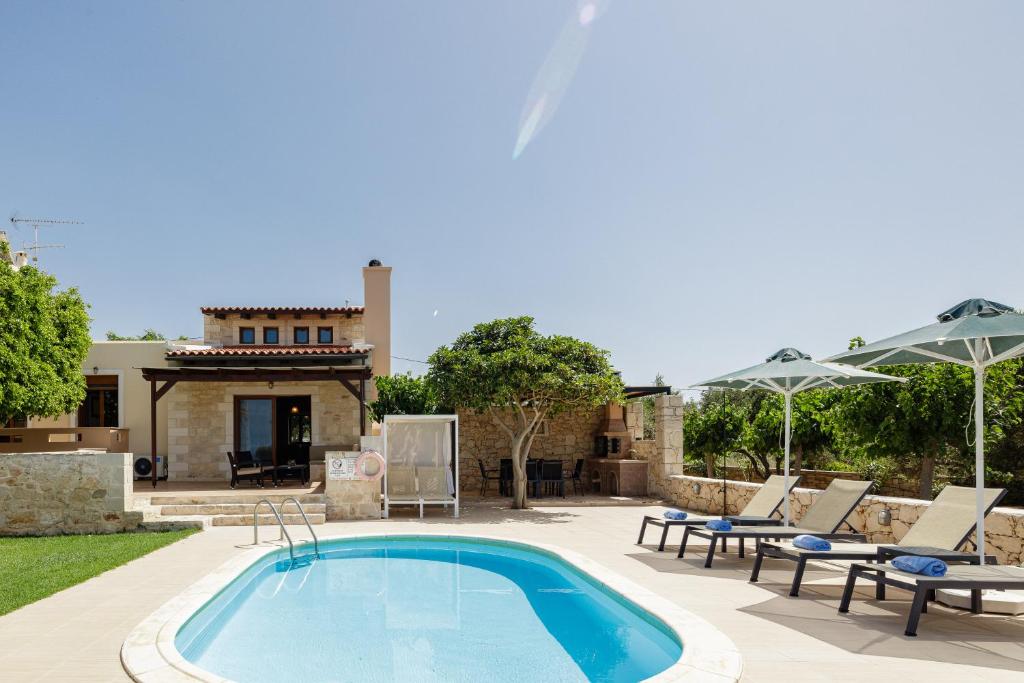 斯泰洛米诺斯Stavromenos Villas - Private Pools & Seaview - 500m from Beach的一个带椅子的游泳池以及一座房子