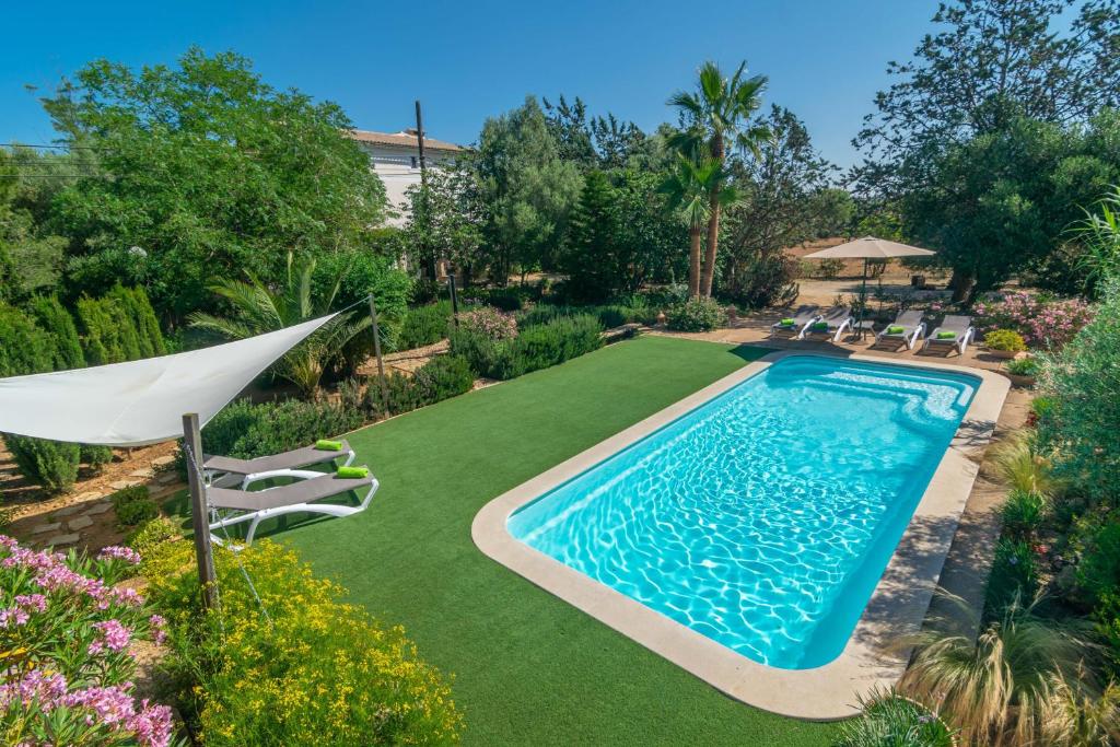 圣马里亚德尔卡米Cas Pilot的庭院内的游泳池配有椅子和遮阳伞