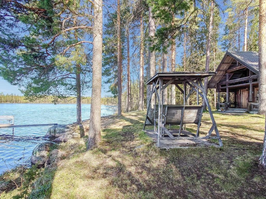 SoiniHoliday Home Mäntylä by Interhome的湖畔凉亭的长椅