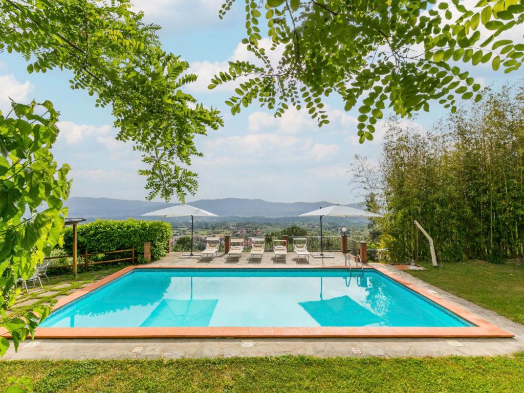 雷杰洛Holiday Home Podere Berrettino-2 by Interhome的一座树木繁茂的庭院内的游泳池