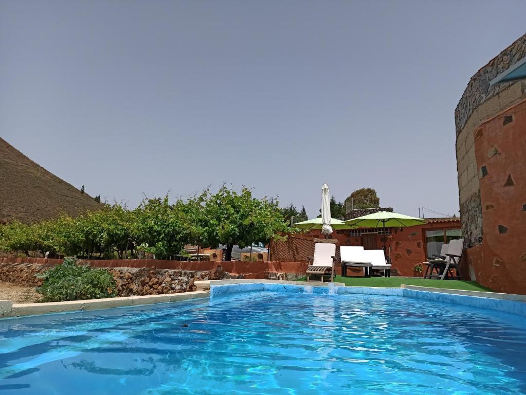 比拉夫洛尔Casa de los abuelos的一座大型蓝色游泳池,位于大楼旁边