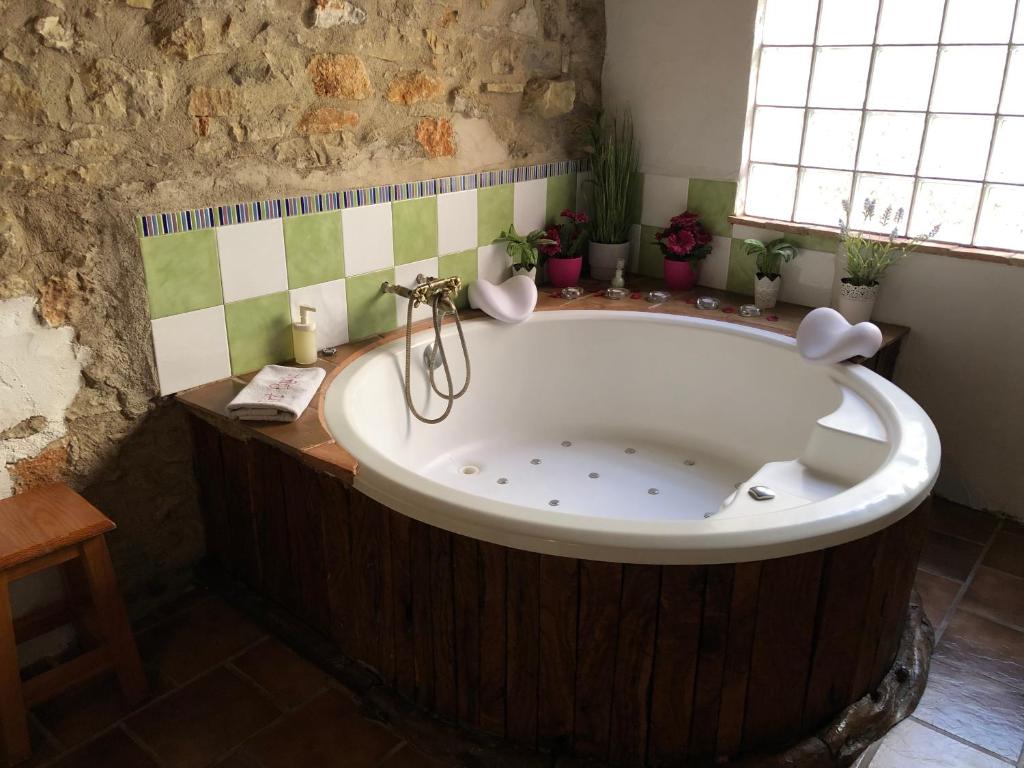 ChertCasa Rustic Suites, JACUZI & LOVE的带窗户的浴室设有大浴缸