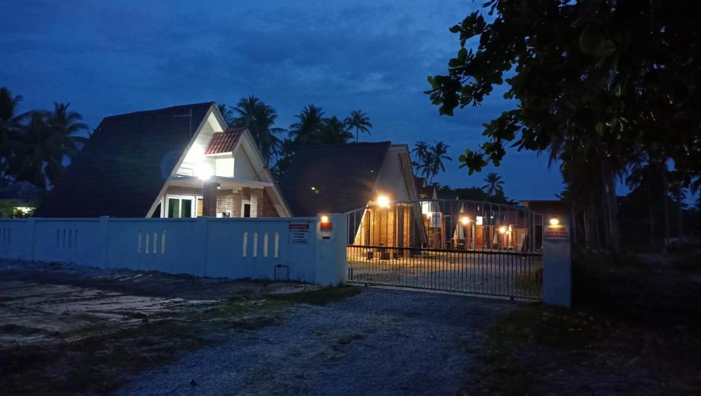 巴西富地Zainab Cottage的夜晚在房子前面有栅栏
