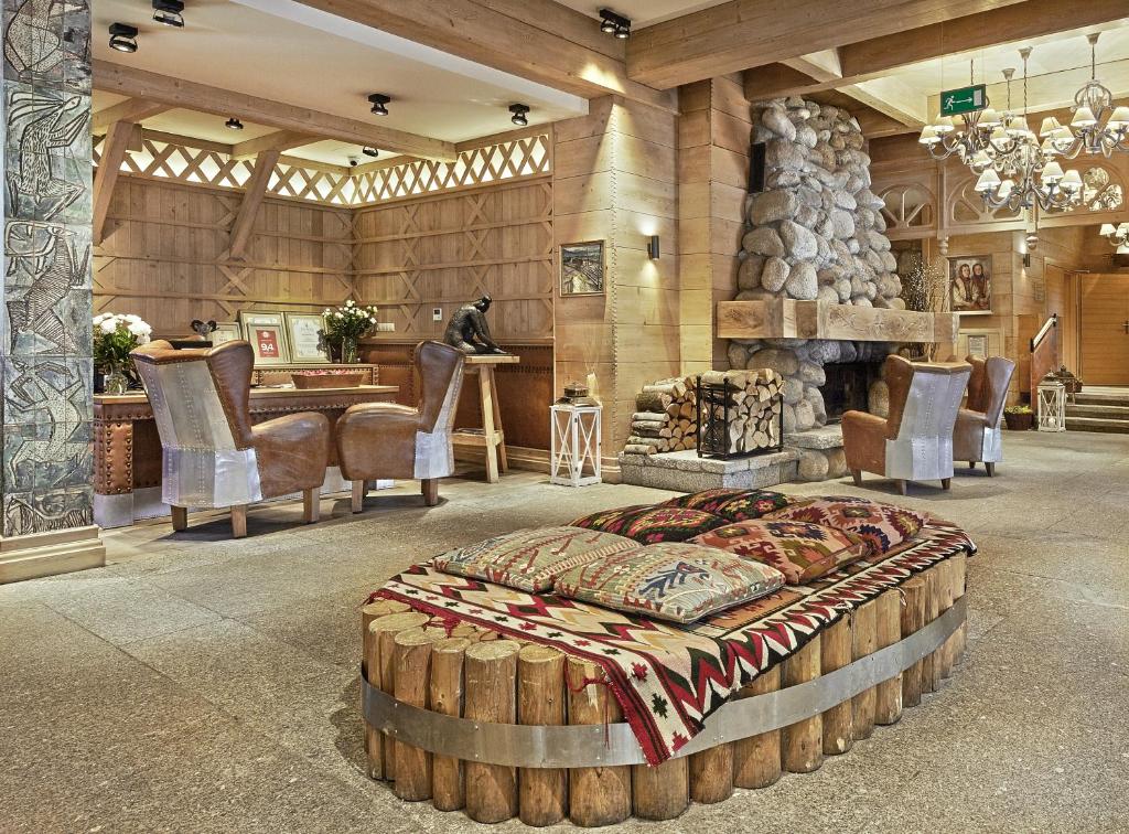 扎科帕内Aries Hotel & SPA Zakopane的大型客房设有一张床和一个壁炉。