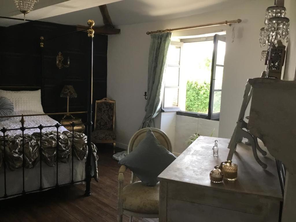 Verteuil-sur-CharenteLa Cour Blanche的卧室配有床、椅子和窗户。