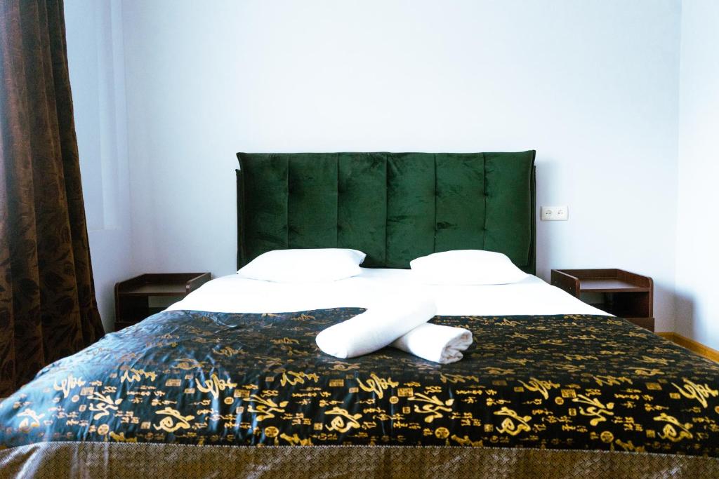 第比利斯Hotel White House的一间卧室配有一张带绿色床头板的床