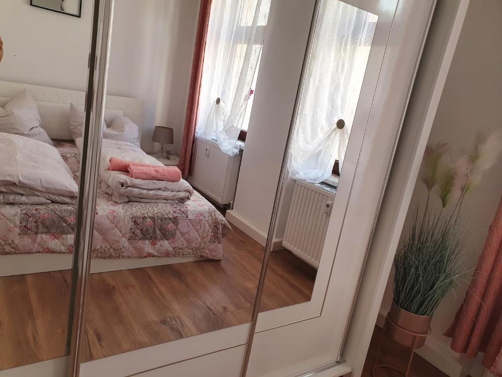 安娜贝格-布赫霍尔茨Da Rebelo (Ferienwohnung)的卧室内的镜子,卧室设有床和窗户