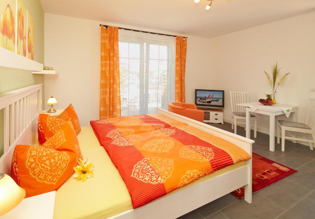 黑灵斯多夫Ferienwohnung Kargoll Wydra in Heringsdorf的一间卧室配有带橙色和橙色枕头的床