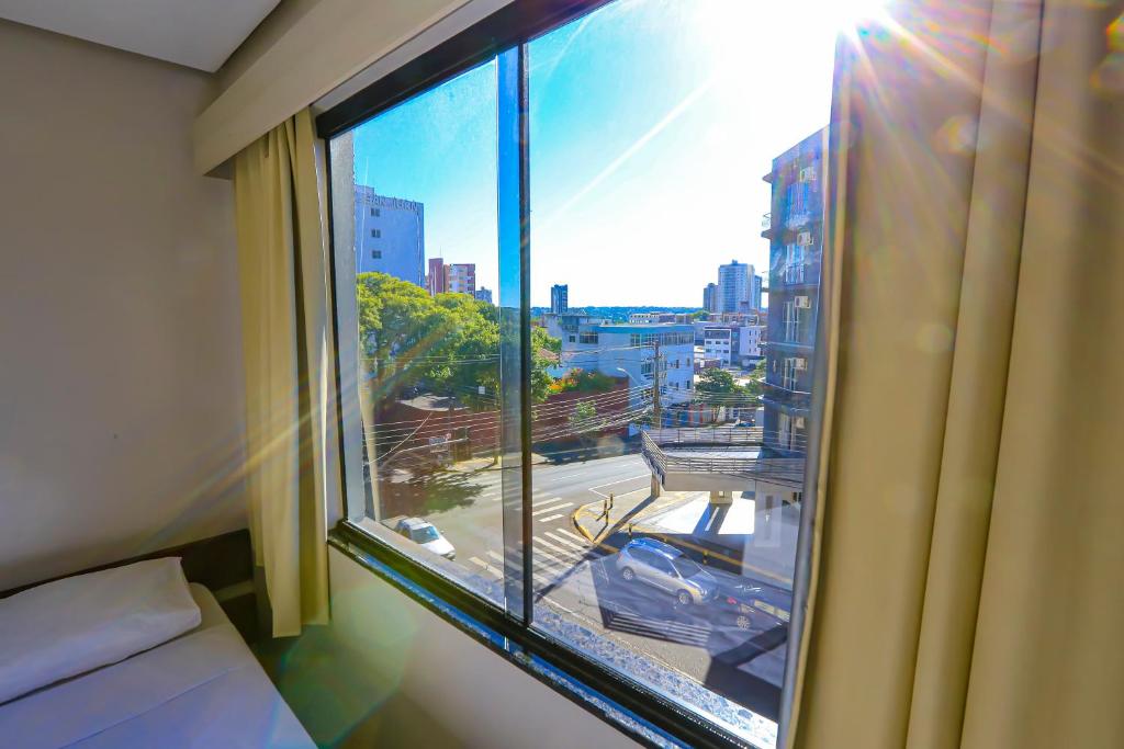 伊瓜苏Foz Express Hotel Centro的一间卧室设有窗户,享有城市美景