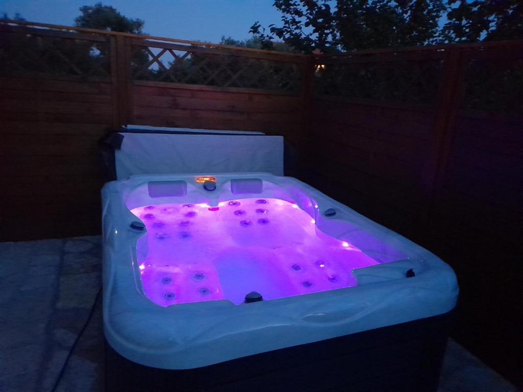 苏科尚Tiny house的后院的按摩浴缸,配有紫色灯