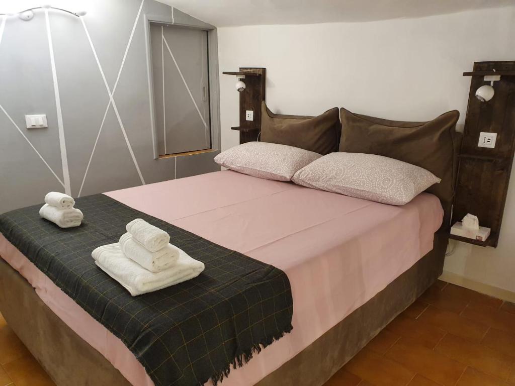 圣雷莫CASA DI MAGGIE的一间卧室配有一张床,上面有两条毛巾