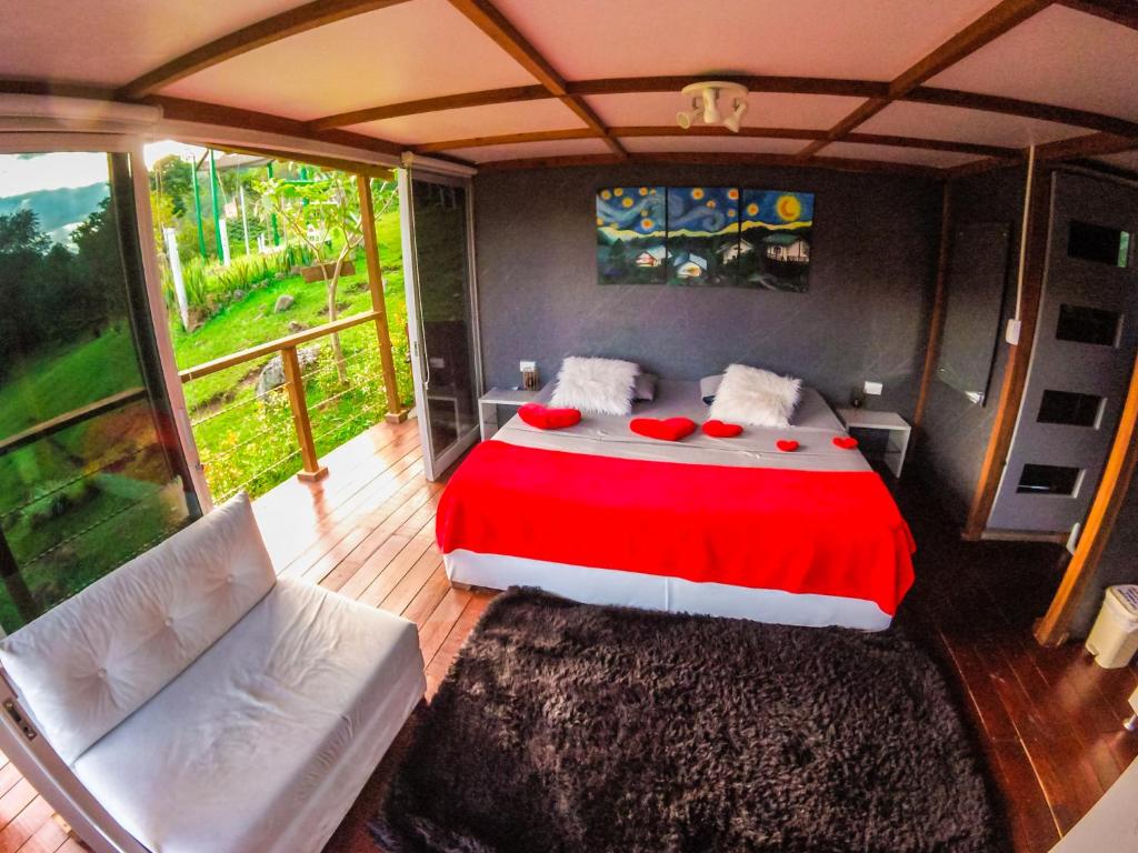 圣奥古斯丁Glamping Adrenalina Extrema的一间卧室配有一张带红色毯子的床