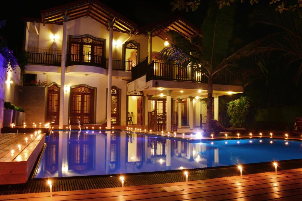 贝鲁沃勒森杜尔别墅酒店的夜间在房子前面的游泳池