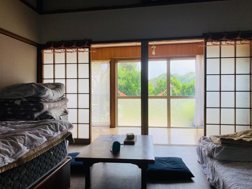 日南Guesthouse Nichinan - Vacation STAY 82913v的客房设有桌子和大窗户。