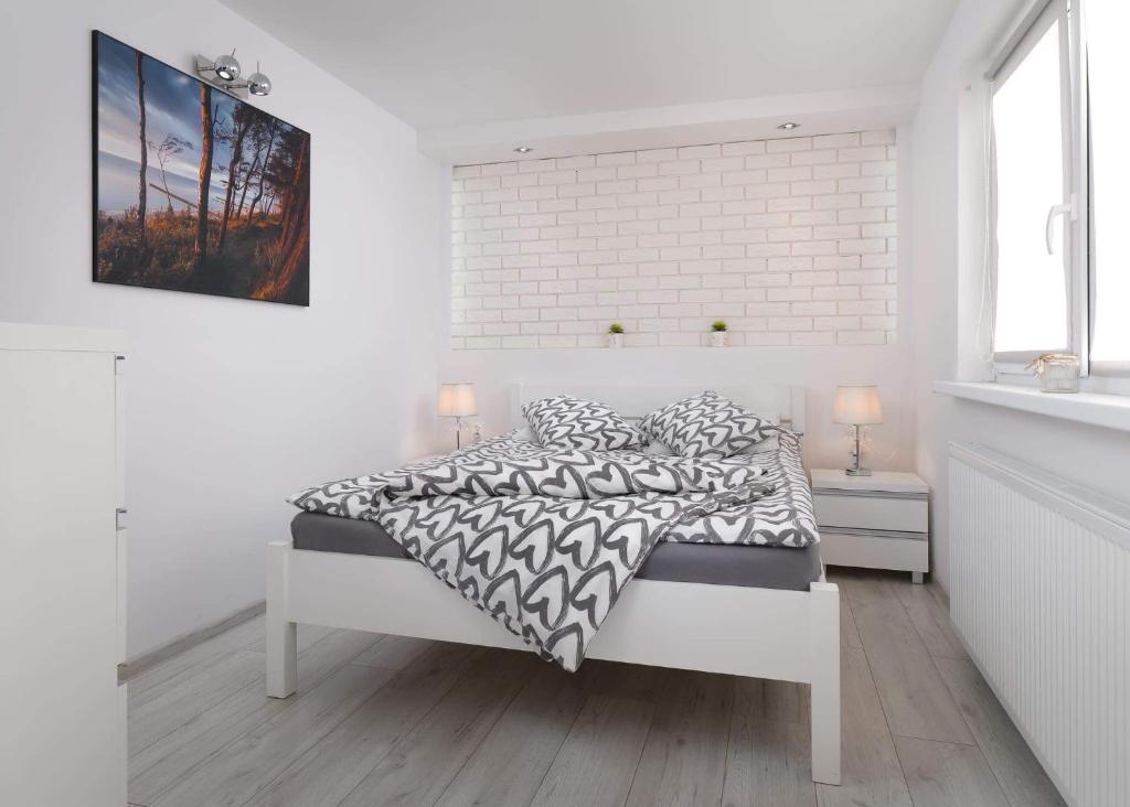 尤斯托尼莫斯基Pokoje Gościnne - HESJOK的白色的卧室,配有床和砖墙