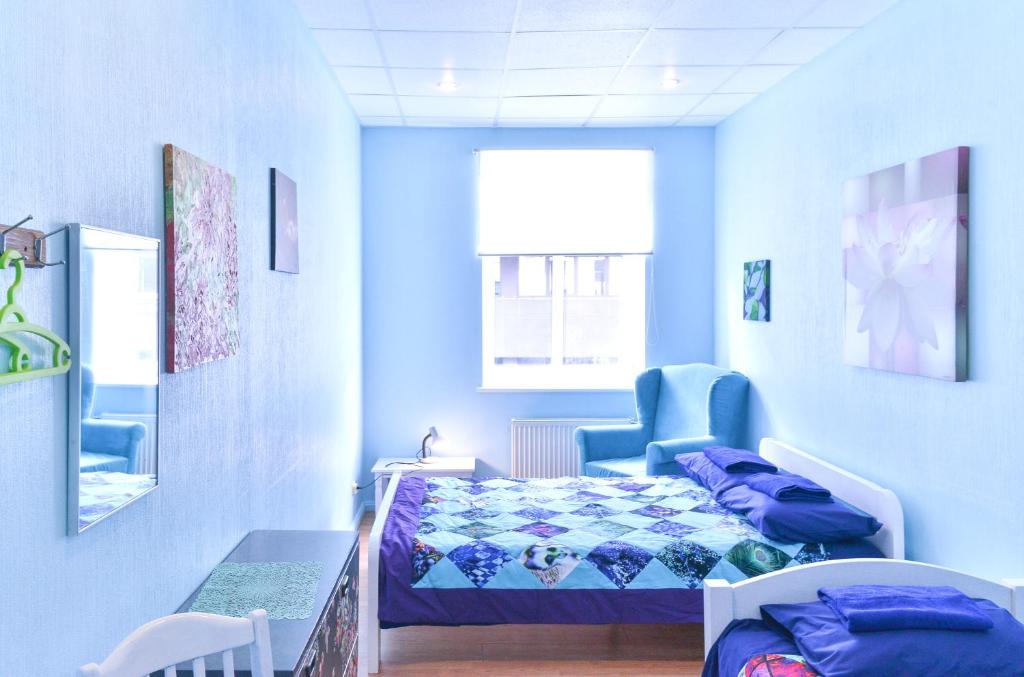 里加中心旅舍的蓝色客房 - 带床和椅子