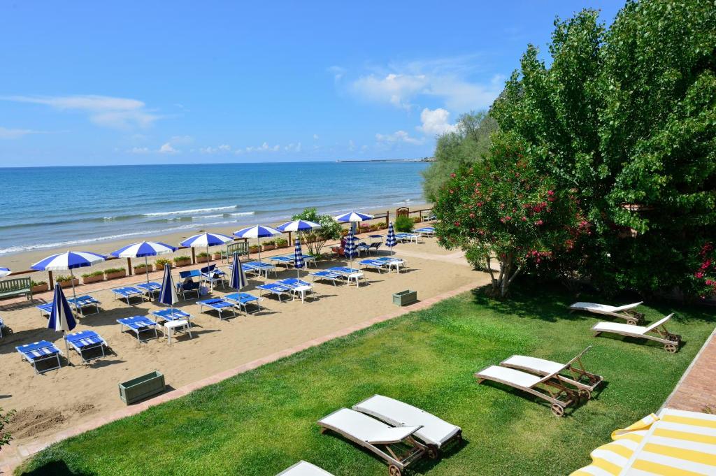 泰拉奇纳阿夸桑塔酒店的海滩上设有椅子和遮阳伞,还有大海