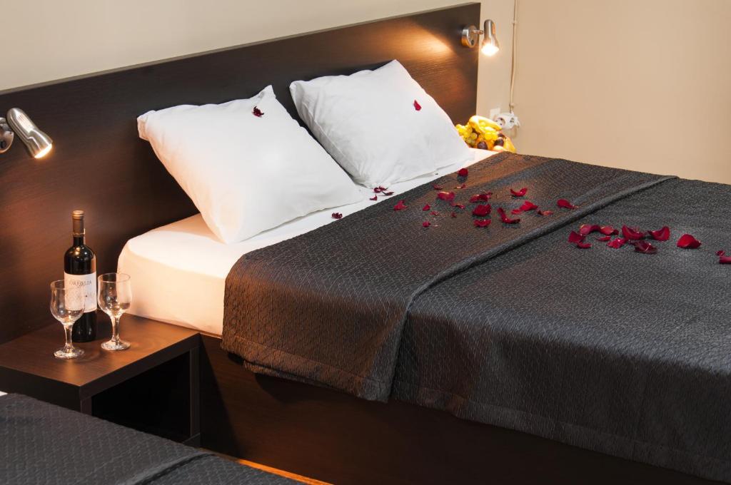 桑丹斯基帕塔利亚家庭酒店的一间卧室,床上有红色玫瑰