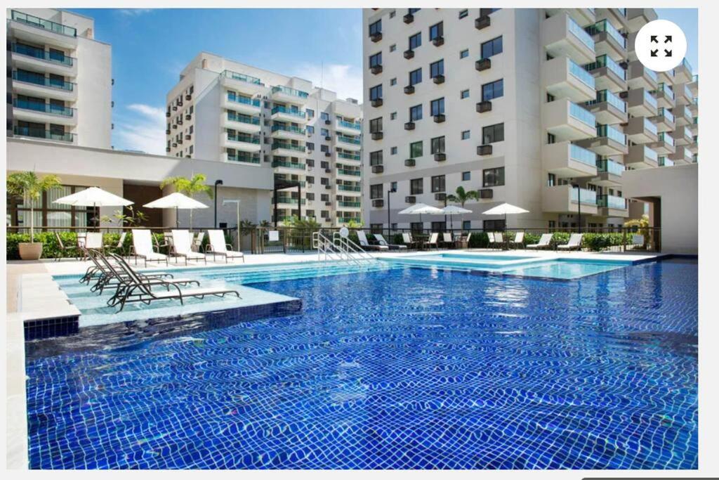里约热内卢Apartamento Padrão em condominio completo no Recreio的大楼前的大型游泳池
